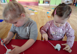 Dzieci malują na biało zęby z tekturki